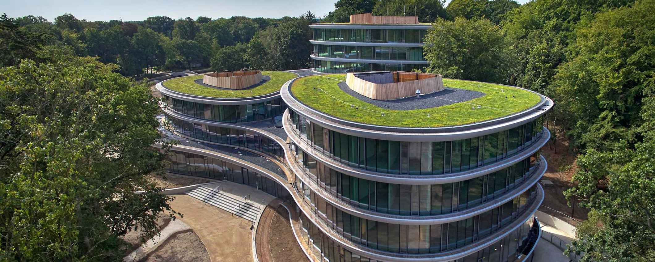 Het kantoor van Triodos Bank, de Reehorst, staat midden in het groen. Het gebouw heeft ronde vormen, veel glas en daken met planten.